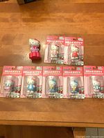 Six sealed Hello Kitty figures and one loose McDonald’s figure displayed on table