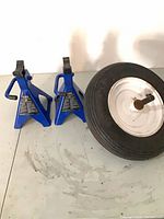 Tire with axle and two blue jack stands