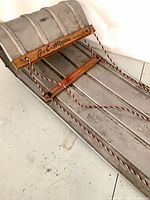 Top view showing aluminum body, wood crossbar with J.C. Higgins branding and braided rope