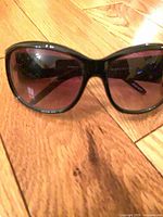 large square black sunglasses with purple lenses