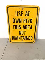Full view of rectangular yellow metal caution sign with text