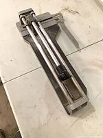 Full view of manual tile cutter showing rails and lever