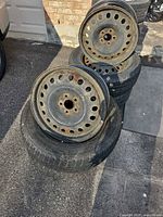 Stack of four tires with two rims visible