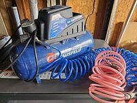 Full view of compressor with both coiled hoses attached