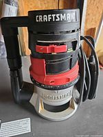 Front view of Craftsman router showing brand, handles, depth adjustment and power cord