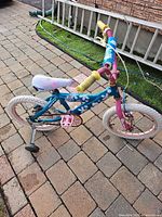 Left side view of entire Huffy Hot Stuff bike showing colors, training wheels and wear