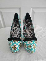 Front view of both pumps showing skull floral print and bows