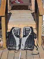 Front view of both Koho goalie pads laid side by side showing full graphic and measuring tape indicating size