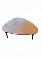 Top view of elliptical teak coffee table with three legs visible