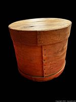 Closed antique bentwood cheese box showing cylindrical form, seam with square nails, and lid