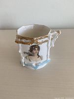Portrait miniature cup front view showing portrait, applied gilt, blue base