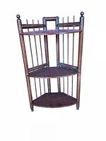 Front view of wooden corner shelf showing three tiers, finials and spindle sides
