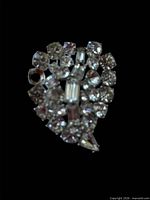 Front view of silver-tone brooch showing clear rhinestones and overall design