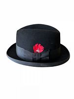 Front view of black fedora showing ribbon band and red feather