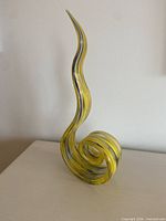 Tall yellow blown glass curlique sculpture on tabletop