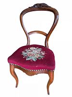Full view first chair showing walnut frame and floral needlepoint seat