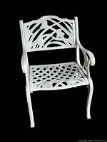 Front view of one white cast iron garden armchair showing decorative back and lattice seat