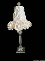 White rose lamp showing fabric petal shade and clear square column base