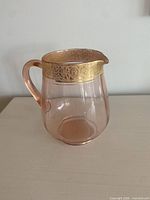 Full view of pink depression glass pitcher, right profile