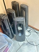 Group of five identical black Lasko bladeless tower units showing overall quantity and design