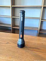 Full view of flashlight standing upright