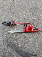 Chainsaw and hedge trimmer full view on ground