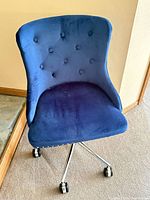 Front view of navy blue velvet armless swivel office chair showing tufted back and seat