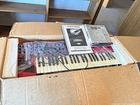 Synthesizer in original box with manual and software visible