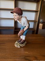 Full view of baseball boy figurine showing pose and attire