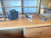 Full lot on desk showing camcorder, battery, charger and Lowepro bag