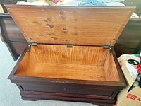 Chest open showing interior wood, lid supports