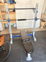 Full view of power rack, bench, barbell and squat pad