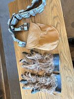 Overview of bandolier, pouch, and pair of faux fur gloves on table