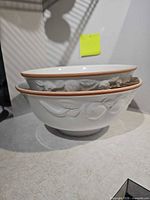 Two stacked ceramic bowls showing exterior fruit motif and rim color