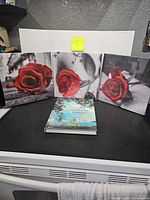 Three rose canvas prints and Maxfield Parrish book displayed together