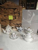 Group shot of all teapots, teacup, saucer and sugar bowl