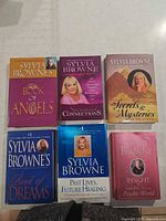 All six Sylvia Browne books laid out front covers visible