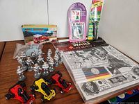 Group shot of entire lot showing poster pad, photo frame, rainbow toy packs, boxed fire truck, loose fire truck, silver soldiers, race cars