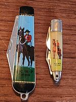 Both pocket knives closed showing RCMP graphics