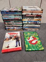 Entire stack of 29 single DVDs plus two box sets arranged on surface