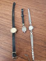 Three vintage ladies wristwatches side-by-side on wooden surface