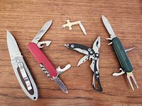 Overview of four folding knives and brass cross pin knife