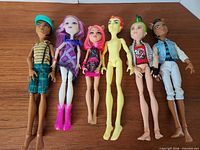 All six dolls side-by-side on wooden surface