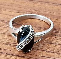 Side view of sterling silver ring showing black onyx cabochon and marcasite band