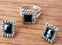 overview of ring and both earrings on wood surface