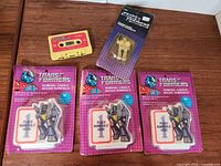 Group shot of cassette, three candle packs, sealed keychain