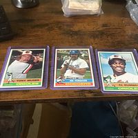Front view of all three 1976 Topps cards in sleeves: Tony Muser, Joe Ferguson, Al Bumbry