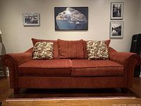 Front view of brick red couch with cushions