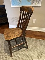 Full view of wooden spindle-back farmhouse chair on carpeted floor