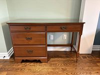 Front view showing five drawers, hardware, turned leg